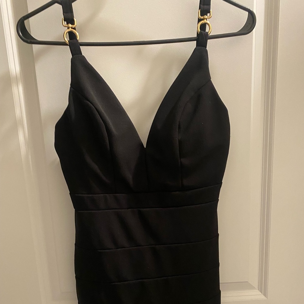 tight fitting formal solid black dress with gold tassels on straps